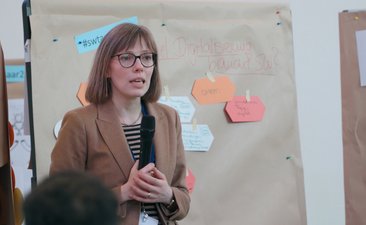 SW-Jahrestagung22_GalleryWalk_Foto_FlorianMaas_MESaar. Bundesgeschäftsführerin SCHULEWIRTSCHAFT Deutschland erläutert Ergebnisse aus der Open-Space-Session "Wie viel Digitalisierung verträgt SCHULEWIRTSCHAFT"